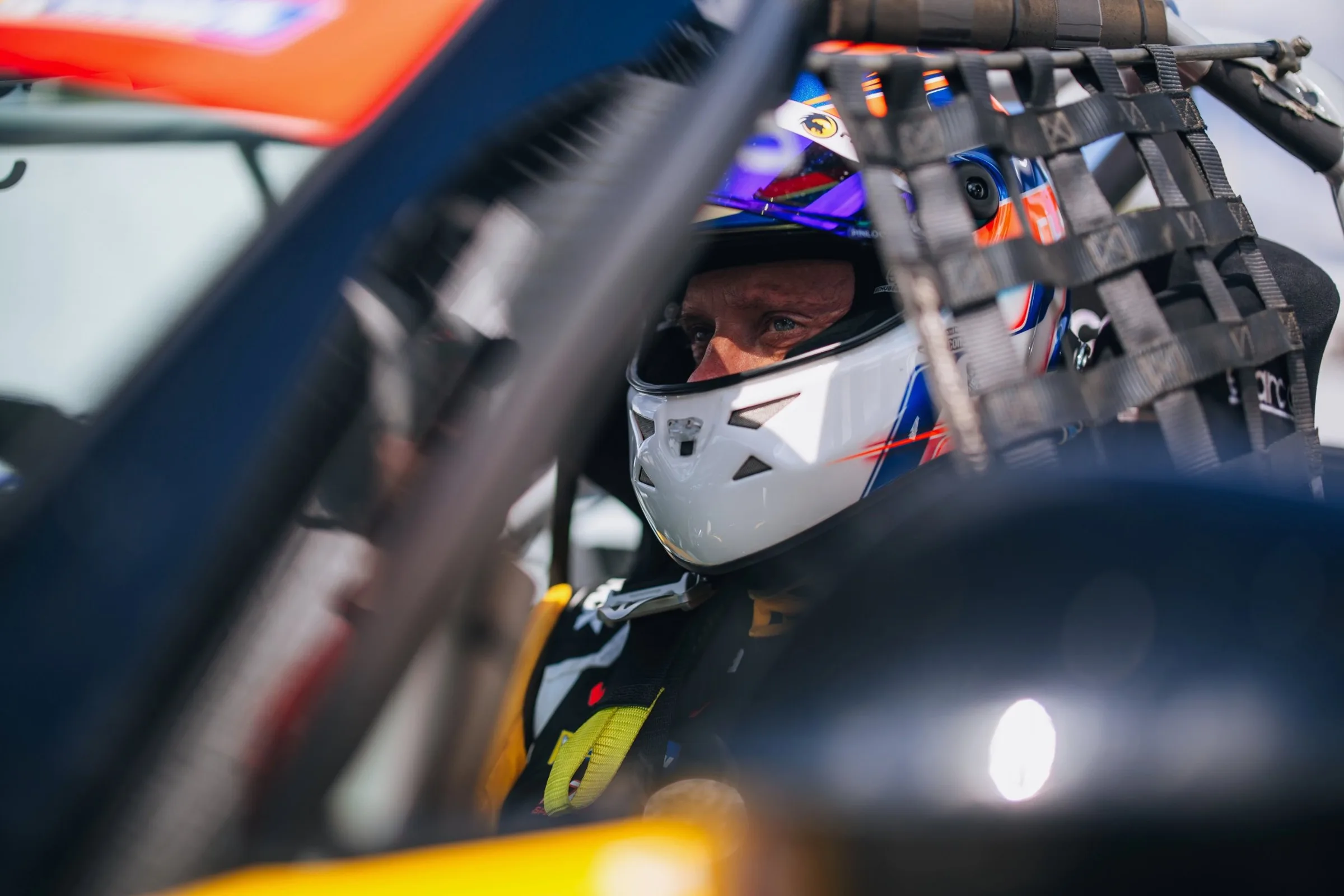 Jameson Riley strapped into the race car, helmet on, waiting for the signal to go
